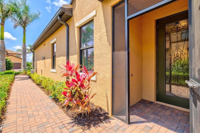 10808 Tarflower Dr Unit 102, Venice, FL 34293 - doorway to property featuring stucco siding and a patio area