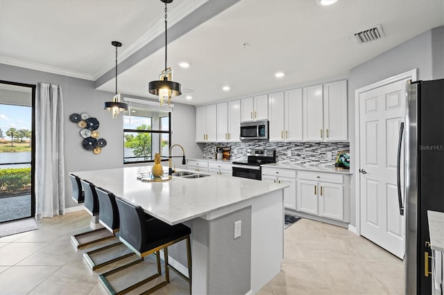 10808 Tarflower Dr Unit 102, Venice, FL 34293 - kitchen with stainless steel appliances, a sink, tasteful backsplash, white cabinetry, and an island with sink