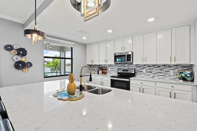 10808 Tarflower Dr Unit 102, Venice, FL 34293 - kitchen featuring appliances with stainless steel finishes, a sink, backsplash, white cabinets, and crown molding