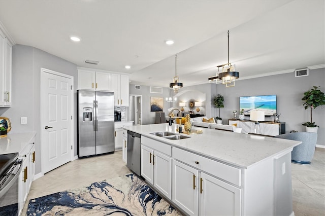 10808 Tarflower Dr Unit 102, Venice, FL 34293 - kitchen featuring appliances with stainless steel finishes, a sink, open floor plan, white cabinetry, and light stone countertops