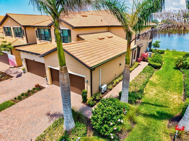 10808 Tarflower Dr Unit 102, Venice, FL 34293 - view of front facade featuring stucco siding, a garage, decorative driveway, and a tile roof