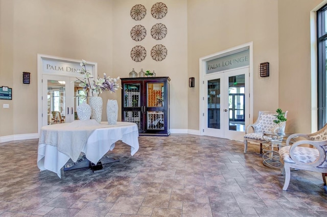10808 Tarflower Dr Unit 102, Venice, FL 34293 - foyer with french doors, a high ceiling, baseboards, stone finish flooring, and healthy amount of natural light