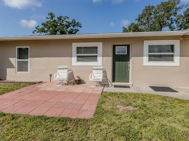 4192 Tarpon Rd, Venice, FL 34293 - back of property with stucco siding, a patio, and a yard