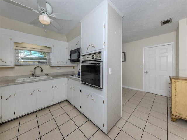 4192 Tarpon Rd, Venice, FL 34293 - kitchen with oven, black microwave, a sink, light tile patterned flooring, and light countertops