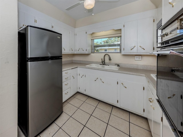 4192 Tarpon Rd, Venice, FL 34293 - kitchen with freestanding refrigerator, a sink, light tile patterned floors, white cabinetry, and a ceiling fan