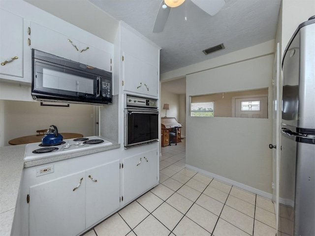 4192 Tarpon Rd, Venice, FL 34293 - kitchen featuring wall oven, black microwave, freestanding refrigerator, white electric cooktop, and light countertops