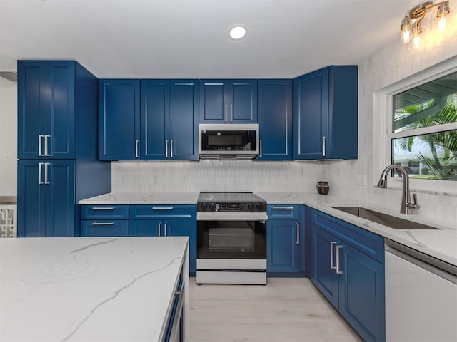 832 Whitecap Cir Unit 5, Venice, FL 34285 - kitchen featuring stainless steel appliances, a sink, blue cabinetry, light stone counters, and recessed lighting