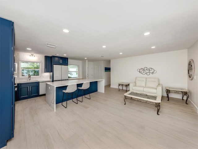 832 Whitecap Cir Unit 5, Venice, FL 34285 - kitchen with built in fridge, a kitchen bar, blue cabinets, light countertops, and baseboards