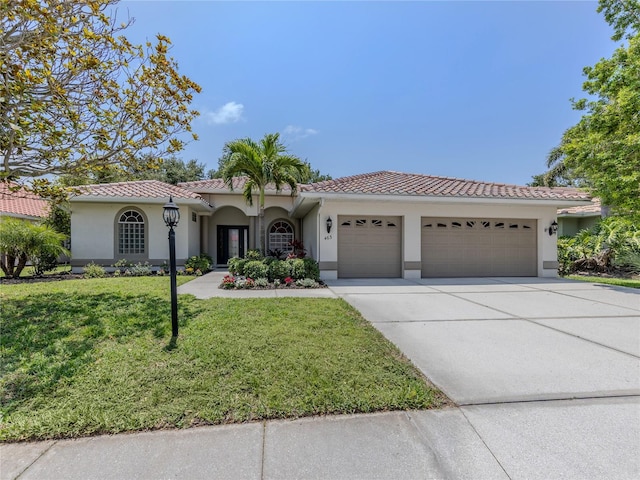 463 Park Trace Blvd, Osprey, FL 34229 - mediterranean / spanish-style home featuring a garage, stucco siding, concrete driveway, a front yard, and a tiled roof