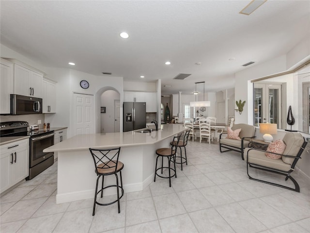 463 Park Trace Blvd, Osprey, FL 34229 - kitchen with stainless steel appliances, a sink, a kitchen bar, a large island with sink, and light tile patterned floors