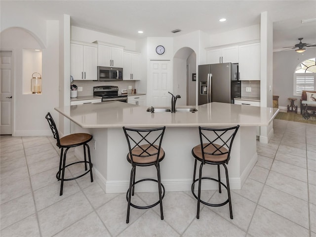 463 Park Trace Blvd, Osprey, FL 34229 - kitchen featuring appliances with stainless steel finishes, a sink, arched walkways, a breakfast bar area, and light countertops