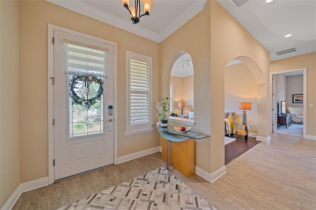 9220 43rd Ter W, Bradenton, FL 34209 - entryway with baseboards, light wood finished floors, arched walkways, a chandelier, and ornamental molding