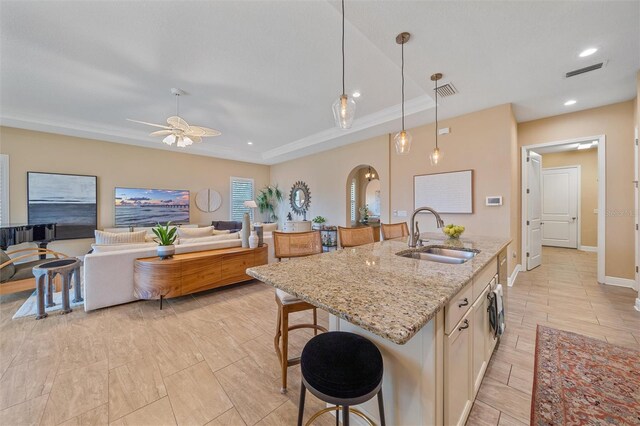9220 43rd Ter W, Bradenton, FL 34209 - kitchen with a sink, ceiling fan, a kitchen breakfast bar, light stone countertops, and decorative light fixtures
