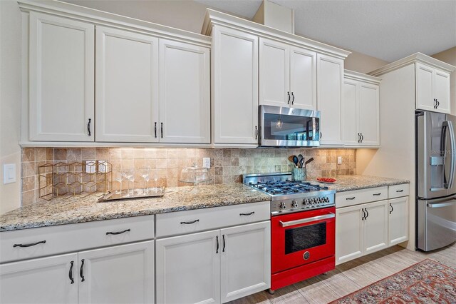 9220 43rd Ter W, Bradenton, FL 34209 - kitchen featuring appliances with stainless steel finishes, white cabinets, backsplash, and light stone countertops