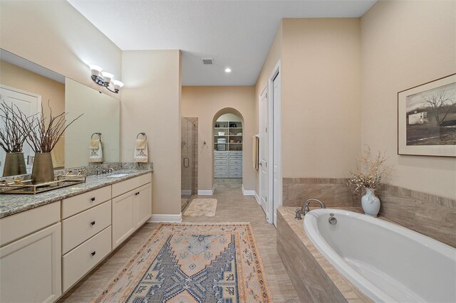 9220 43rd Ter W, Bradenton, FL 34209 - full bath with vanity, a garden tub, a stall shower, a walk in closet, and recessed lighting