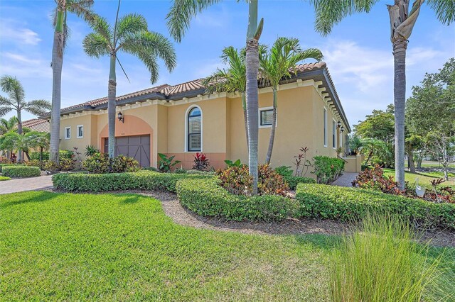 9220 43rd Ter W, Bradenton, FL 34209 - view of home's exterior with a garage, stucco siding, a yard, and a tile roof