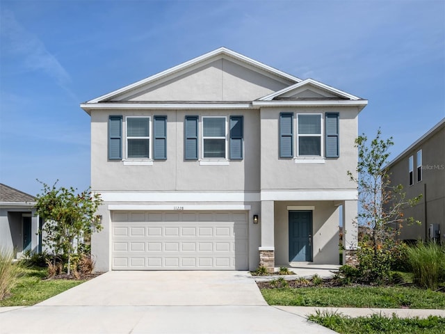 view of front of house with stucco siding, concrete driveway, and an attached garage