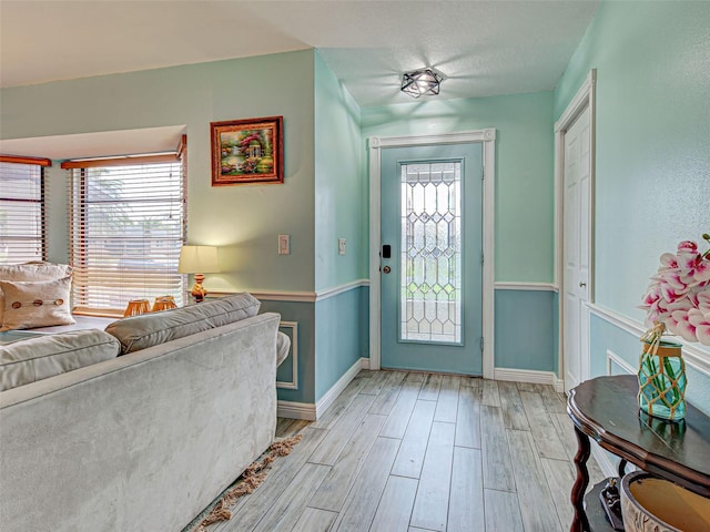 5832 Monroe Rd, Venice, FL 34293 - foyer entrance featuring light wood finished floors, baseboards, and a textured ceiling