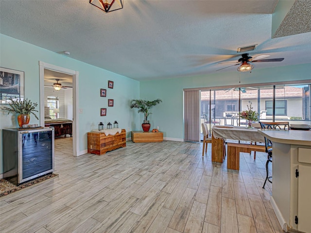 5832 Monroe Rd, Venice, FL 34293 - living room featuring ceiling fan, light wood finished floors, a textured ceiling, and plenty of natural light