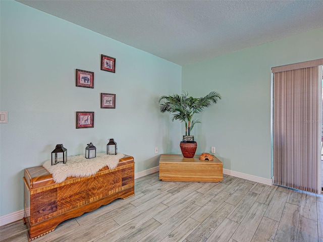 5832 Monroe Rd, Venice, FL 34293 - living area with light wood finished floors, baseboards, and a textured ceiling