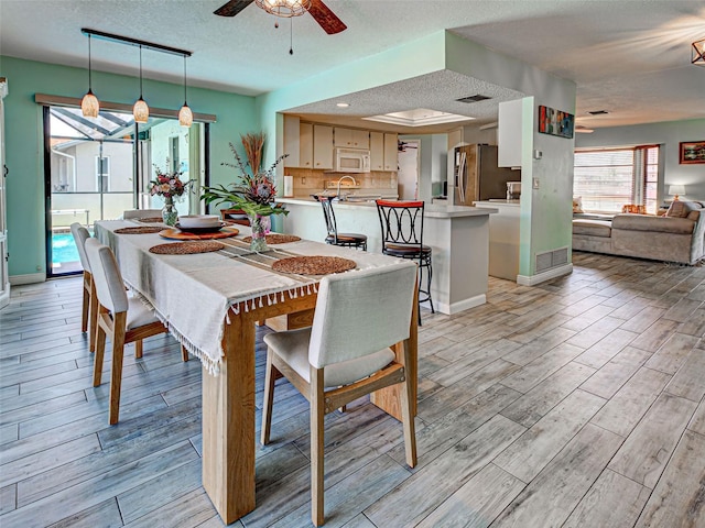5832 Monroe Rd, Venice, FL 34293 - dining space with a textured ceiling, ceiling fan, light wood finished floors, and baseboards