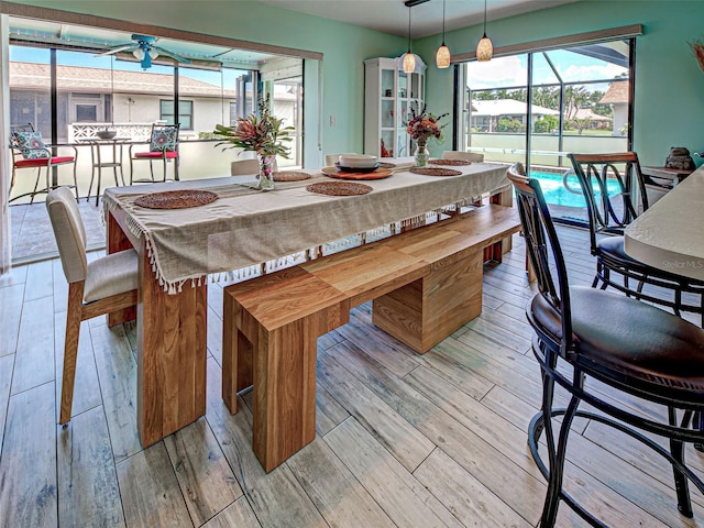 5832 Monroe Rd, Venice, FL 34293 - dining room featuring ceiling fan, light wood-style floors, and a sunroom
