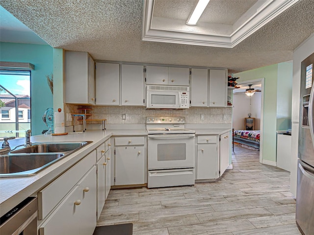5832 Monroe Rd, Venice, FL 34293 - kitchen with white appliances, a textured ceiling, a sink, light countertops, and light wood-type flooring