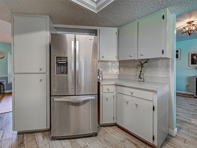 5832 Monroe Rd, Venice, FL 34293 - kitchen featuring stainless steel fridge with ice dispenser, a textured ceiling, light countertops, light wood-style flooring, and backsplash