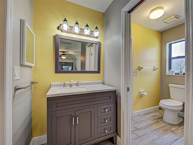 5832 Monroe Rd, Venice, FL 34293 - half bath featuring vanity, toilet, baseboards, ceiling fan, and wood finished floors