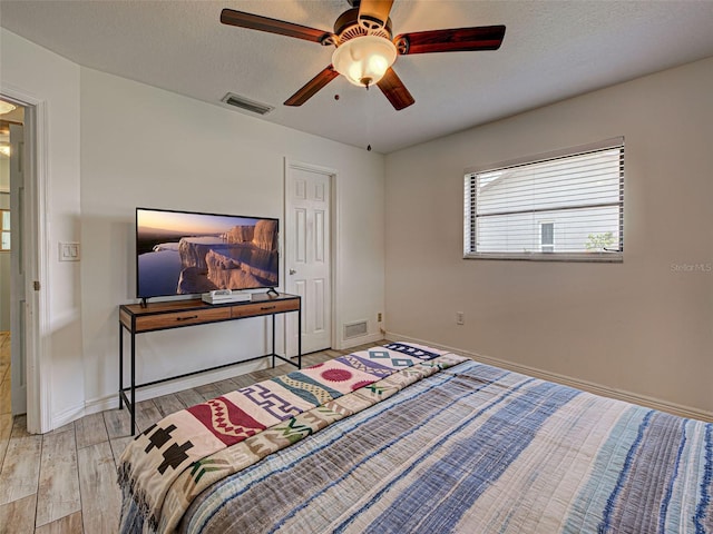 5832 Monroe Rd, Venice, FL 34293 - bedroom with wood finished floors, baseboards, ceiling fan, and a textured ceiling