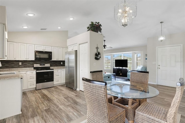 25509 Arequipa Dr, Punta Gorda, FL 33983 - kitchen featuring appliances with stainless steel finishes, light wood-style flooring, white cabinets, vaulted ceiling, and a sink