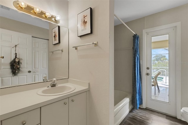 25509 Arequipa Dr, Punta Gorda, FL 33983 - bathroom with wood finished floors, vanity, shower / tub combo, and toilet