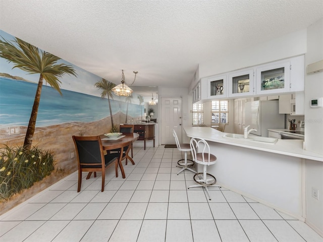 528 W Venice Ave Unit 1, Venice, FL 34285 - dining space with a textured ceiling, a chandelier, and light tile patterned floors