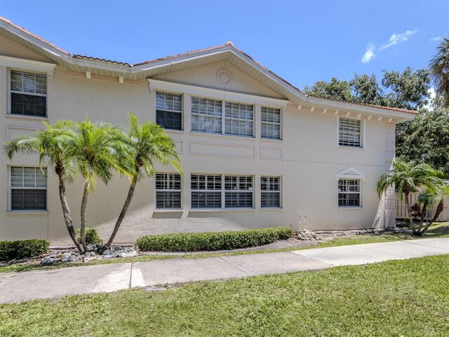 528 W Venice Ave Unit 1, Venice, FL 34285 - view of front of home with stucco siding, a front yard, and a tiled roof