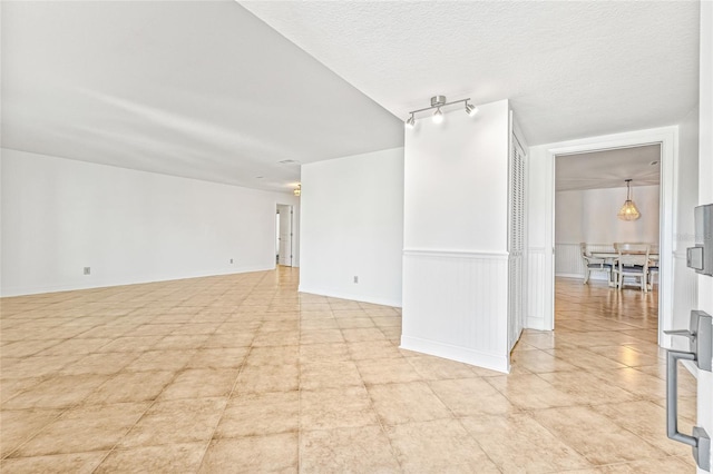 empty room featuring a wainscoted wall