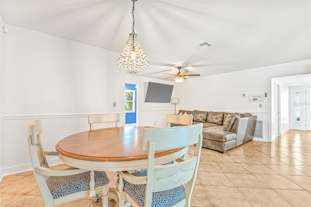 dining area featuring ceiling fan, a chandelier, and light tile patterned floors
