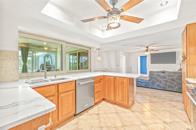 kitchen with dishwasher, a peninsula, ceiling fan, open floor plan, and a sink