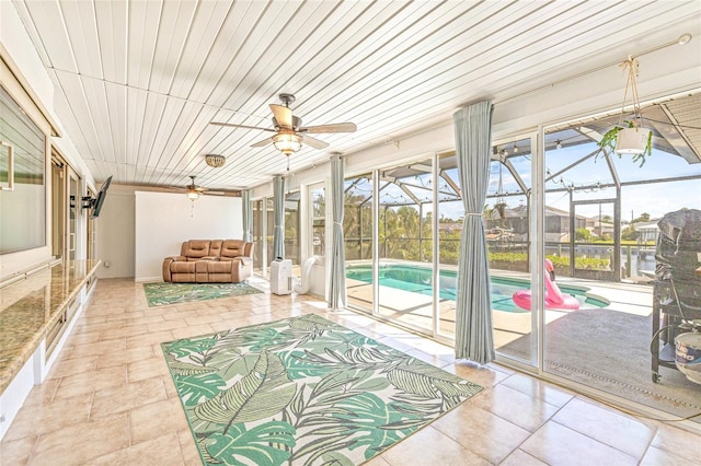 unfurnished sunroom with outdoor lounge area, a ceiling fan, and a pool