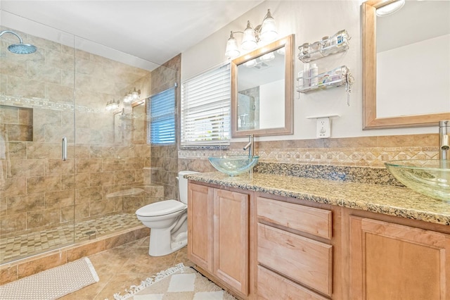 full bath with a shower stall, toilet, tile patterned flooring, and double vanity