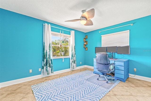 office featuring a textured ceiling, ceiling fan, and baseboards