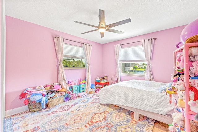 bedroom with a ceiling fan and a textured ceiling