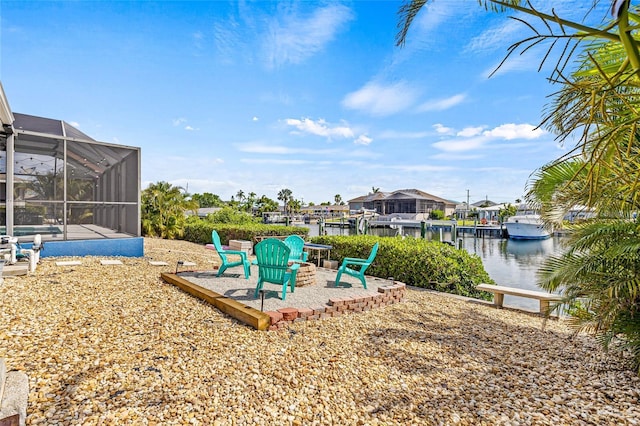 view of yard with a patio, a water view, and glass enclosure