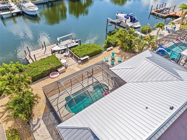 dock area featuring a water view, boat lift, and an outdoor pool