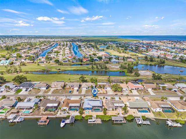 aerial view of property and surrounding area with nearby suburban area and a large body of water
