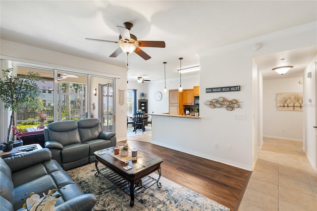 600 Gardens Edge Dr Unit 613, Venice, FL 34285 - living room with ceiling fan, crown molding, baseboards, and light wood-style flooring