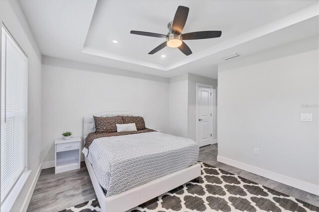 12031 Saragossa Ln, North Port, FL 34287 - bedroom featuring a raised ceiling, baseboards, wood finished floors, recessed lighting, and ceiling fan