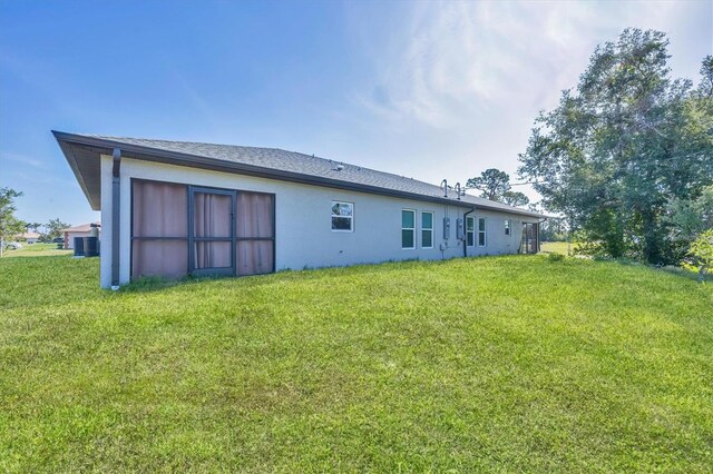12031 Saragossa Ln, North Port, FL 34287 - rear view of house featuring stucco siding and a lawn