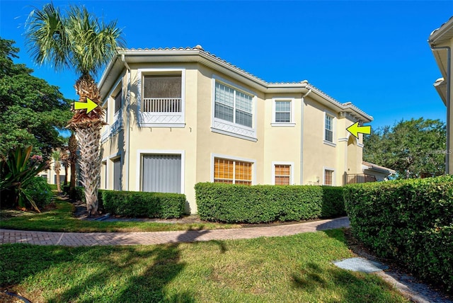 212 Triano Cir Unit 212, Venice, FL 34292 - view of home's exterior featuring stucco siding, a lawn, and a tile roof