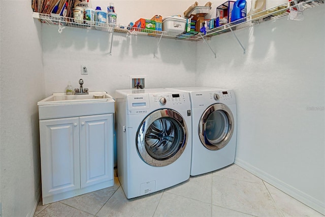 212 Triano Cir Unit 212, Venice, FL 34292 - laundry room featuring washer and dryer, cabinet space, light tile patterned floors, and baseboards