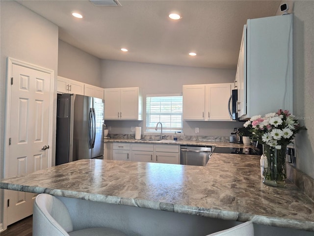 3003 58th Way E, Palmetto, FL 34221 - kitchen featuring stainless steel appliances, a sink, a peninsula, vaulted ceiling, and recessed lighting
